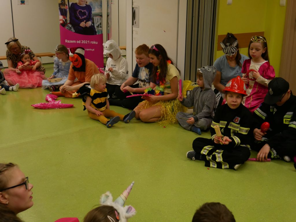 balowicze siedzą w kółku na podłodze w sali