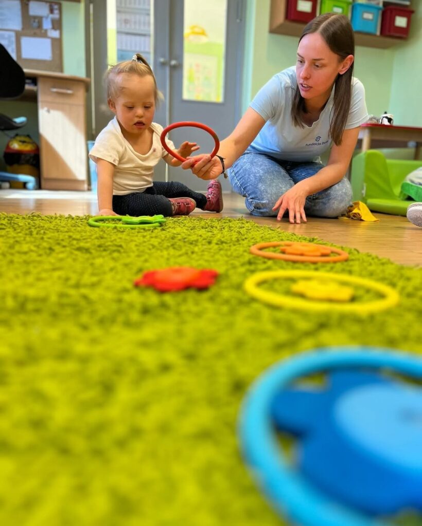 dziecko z terapeutklą na podłodze