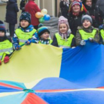 korowód fundacji dom 2017 dzieci z przedszkola trzymają chustę klanzy